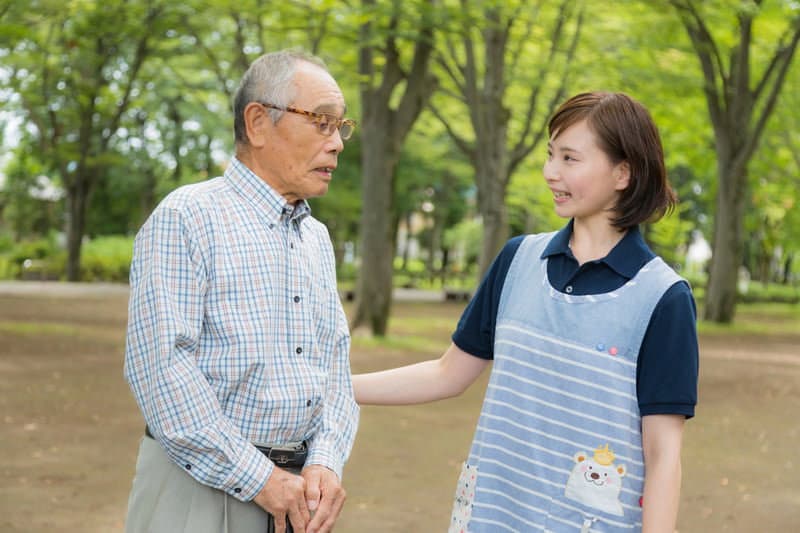 高齢の男性と目線を合わせて話す介護スタッフ