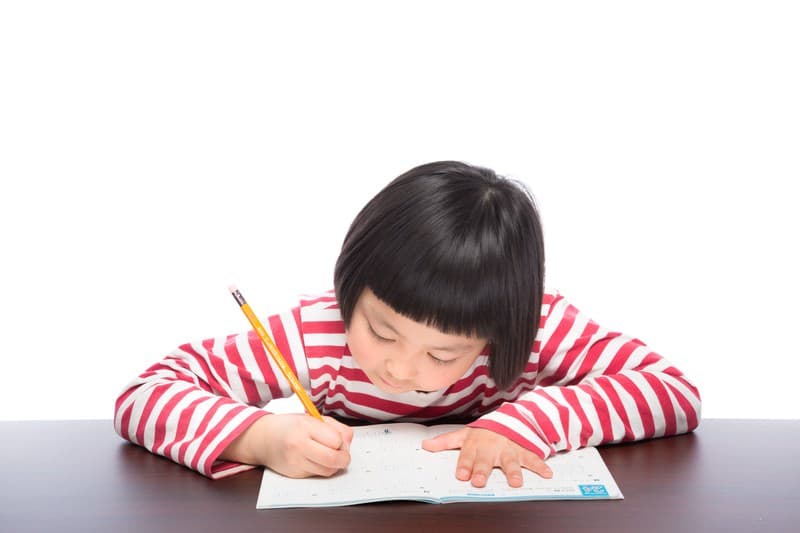 自宅の机で宿題に取り組むお子さま